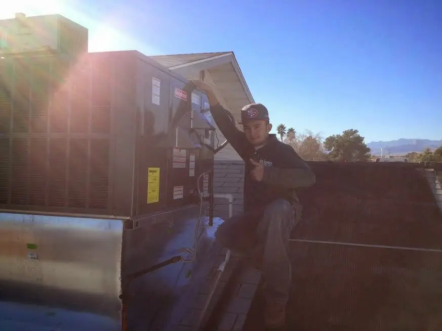 HVAC technician performing Boiler Repair on a rooftop unit in San Angelo